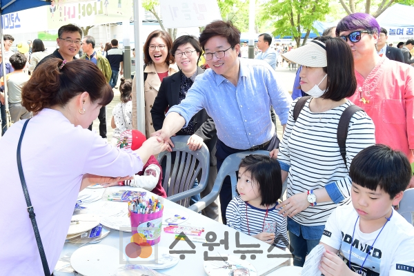 염태영 시장이 만석공원에서 열린 '수원 어린이·청소년 한마당'에 참여한 가족과 인사하고 있다