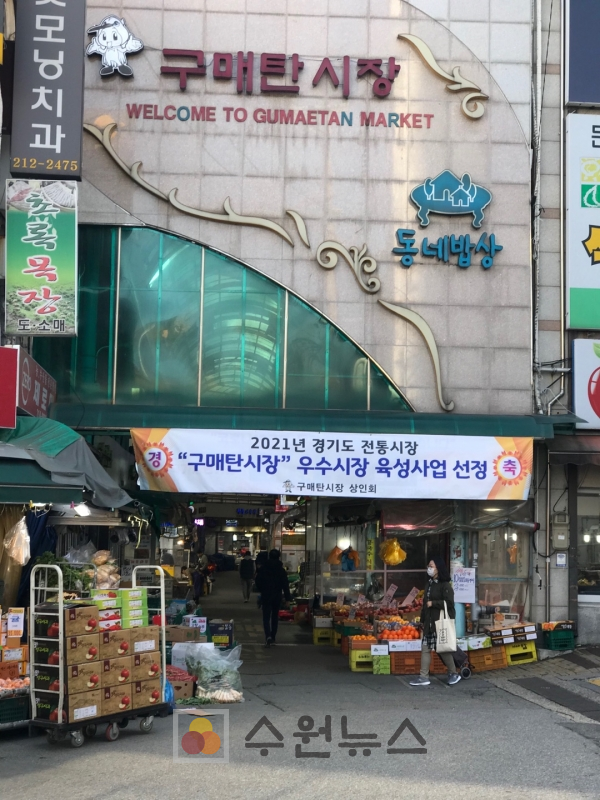 구매탄시장 입구에 우수시장 육성사업 선정을 축하하는 상인회의 현수막이 걸려 있는 모습