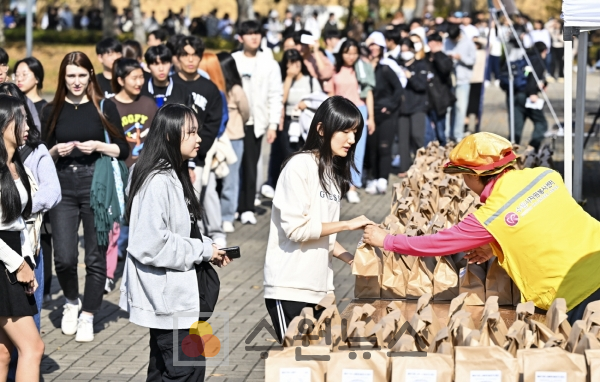 지난 2일 수원 성균관대학교 자연캠퍼스에서 열린 ‘찾아가는 사랑의 밥차’에 참여한 대학생들이 줄지어 서 있다.
